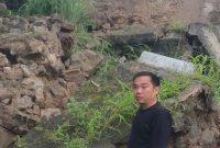 Seorang warga menunjukkan material tembok taman yang longsor di kawasan Lampu Merah Sumur Buang, Kelurahan Kaduagung Timur, Kecamatan Cibadak, Kabupaten Lebak.