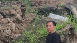 Seorang warga menunjukkan material tembok taman yang longsor di kawasan Lampu Merah Sumur Buang, Kelurahan Kaduagung Timur, Kecamatan Cibadak, Kabupaten Lebak.