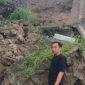 Seorang warga menunjukkan material tembok taman yang longsor di kawasan Lampu Merah Sumur Buang, Kelurahan Kaduagung Timur, Kecamatan Cibadak, Kabupaten Lebak.