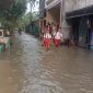 Dua orang siswa saat melintasi genangan air di Perumahan Mustika, Tigaraksa, Kabupaten Tangerang, Banten, Senin (6/5/2026)