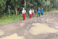 Sejumlah siswa sekolah dasar (SD) saat melintasi jalan di Kampung Cipasung, Desa Sukarendah, Kecamatan Warunggunung, Kabupaten Lebak, Banten, yang rusak selama belasan tahun dan belum mendapat perbaikan, Minggu (4/10/2026). Warga berharap pemerintah segera memperbaiki ruas jalan yang menjadi akses utama masyarakat tersebut.