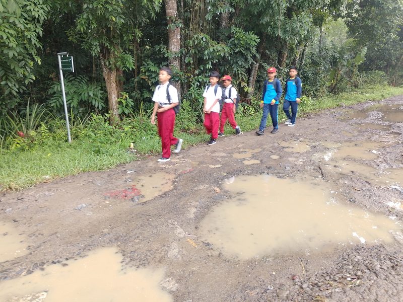 Sejumlah siswa sekolah dasar (SD) saat melintasi jalan di Kampung Cipasung, Desa Sukarendah, Kecamatan Warunggunung, Kabupaten Lebak, Banten, yang rusak selama belasan tahun dan belum mendapat perbaikan, Minggu (4/10/2026). Warga berharap pemerintah segera memperbaiki ruas jalan yang menjadi akses utama masyarakat tersebut.