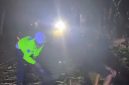 Anggota Satlantas Polres Lebak bersama warga mengevakuasi pohon lapuk yang tumbang dan menutup badan Jalan Nasional Rangkasbitung-Cipanas di wilayah Narimbang, Kabupaten Lebak, Banten, Jumat (23/10/2026) malam.