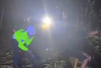 Anggota Satlantas Polres Lebak bersama warga mengevakuasi pohon lapuk yang tumbang dan menutup badan Jalan Nasional Rangkasbitung-Cipanas di wilayah Narimbang, Kabupaten Lebak, Banten, Jumat (23/10/2026) malam.